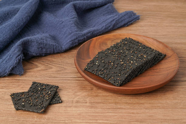 istock A pile of biscuits made of black sesame lies on a solid wooden table 1470493664