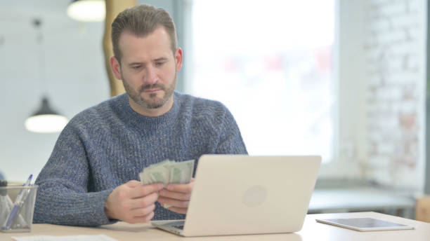istock Middle Aged Man Counting Dollar in Office 1470494157