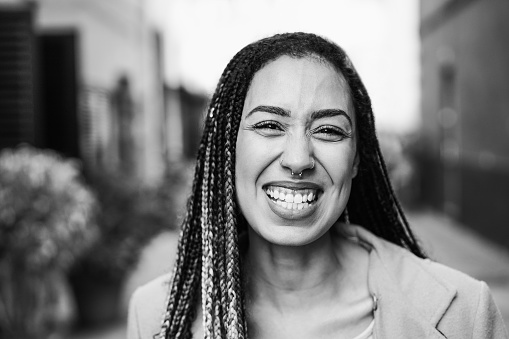 Mixed race girl smiling in front of camera during winter time - Focus on face - Black and white editing