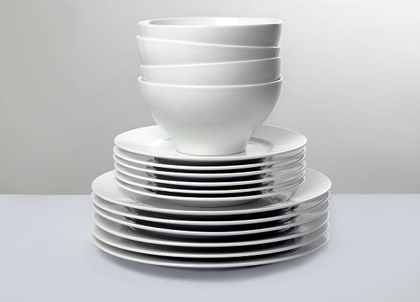 Stack of Commercial White Dishes on Monochromatic Background stock photo