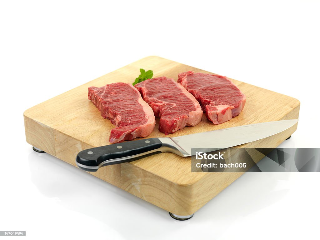 Porterhouse Steaks Porterhouse steak on a chopping board isolated against a white background Beef Stock Photo