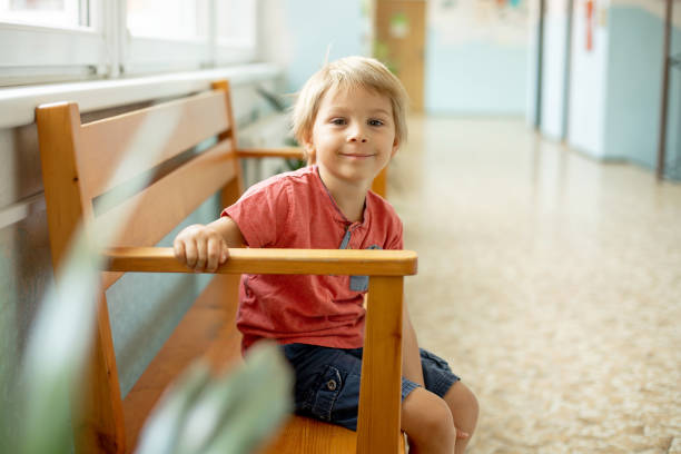 istock Preschool child, sitting on a desk at school, having lesson, learning 1470495973