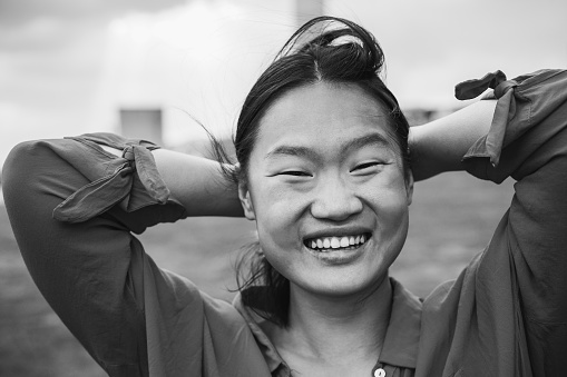 Young asian girl smiling on camera outdoor - Focus on face - Black and white editing