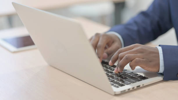 istock Side View of African Male Hands Typing on Laptop 1470497955