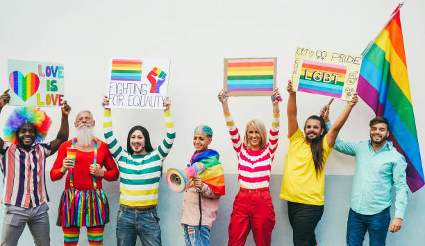 istock Gay people having fun at pride parade with LGBT flags and banners outdoors - Main focus on right man face 1470498316