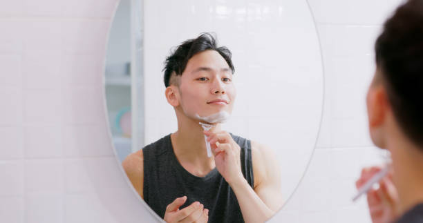 男は剃毛するためにかみそりを使う - razor ストックフォトと画像