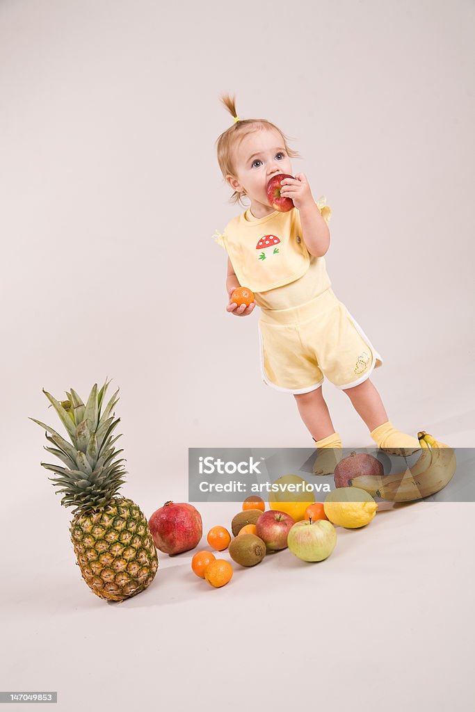Niños de un año de edad con frutas en el estudio - Foto de stock de Abundancia libre de derechos
