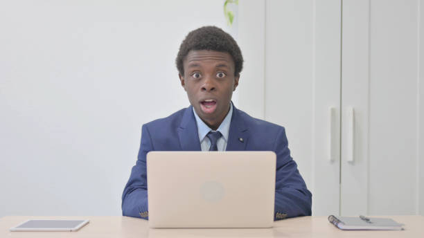 istock Young African Businessman Shocked While Working on Laptop 1470499101