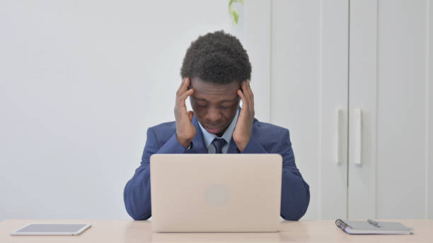 istock Young African Businessman with Headache Working on Laptop 1470500498