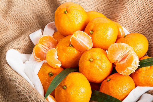 Tangerines with leaf on rustic wooden background, copy space, flat lay.