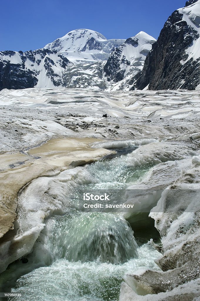 Flusso d'acqua proviene da moutain alto picco attraverso il ghiacciaio. - Foto stock royalty-free di Acqua