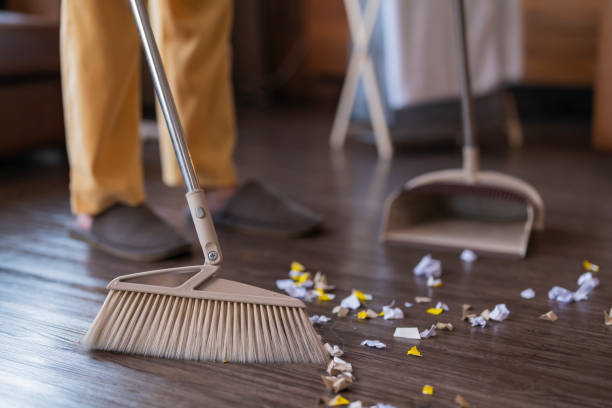 istock Happiness Asian young adult doing house work sweeping floor with a broom while moving in a new house 1470501579