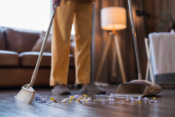 istock Happiness Asian young adult doing house work sweeping floor with a broom while moving in a new house 1470501582