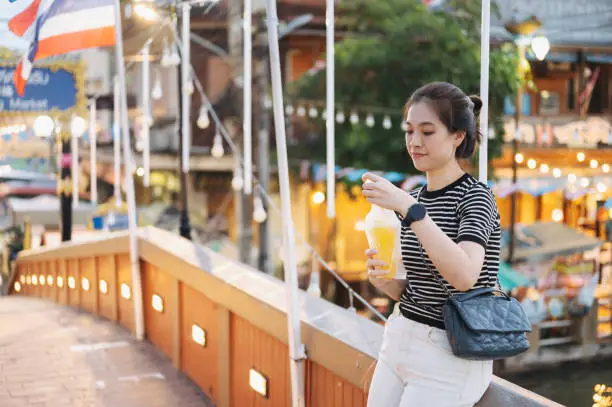 Modern young office women holding coconut juice and looking for vintage cloths in local nightmarket