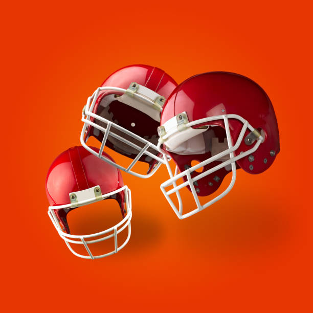 istock Three Floating Red American football helmets on orange gradient 1470505675