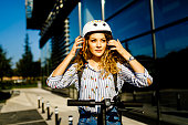 Beautiful woman adjusting crash helmet