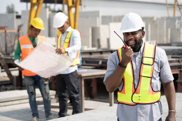 istock Portrait African American engineer man use walkie talkie with team working with paper work and precast cement factory background 1470508207