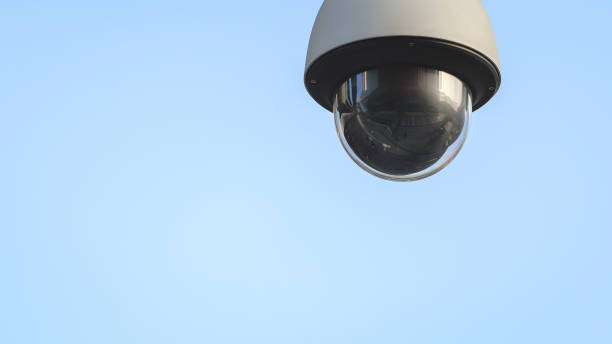 nahaufnahme der außenkuppelüberwachung cctv isoliert mit blauem himmelshintergrund. überwachungssystem für öffentliche überwachungskameras und verbrechensschutzkonzept. - security camera dome security system security stock-fotos und bilder
