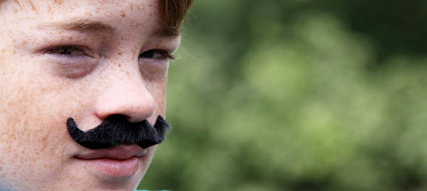 Boy dressed up in fake mustache