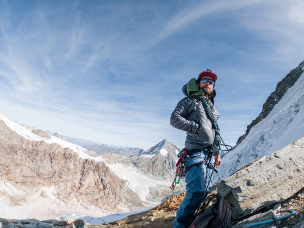 mountain climber reaching summit - conquering adversity wilderness area aspirations achievement imagens e fotografias de stock