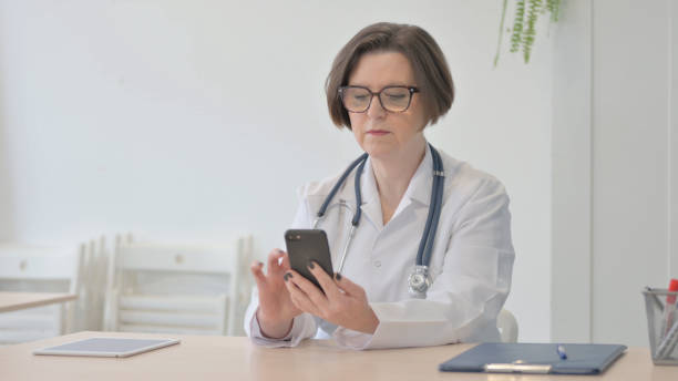 istock Senior Doctor Browsing Smartphone in Clinic 1470517053