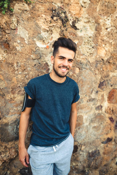 istock man with arm crossed smiling against the wall 1470517951
