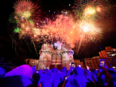 Valencia, Comunidad Valenciana, Spain - February 26: People enjoying fireworks on Fallas' opening ceremony in front of the Torres de Serrano.\n\nLas Fallas or \