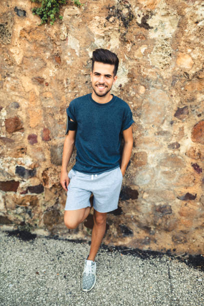 istock man with arm crossed smiling against the wall 1470518552
