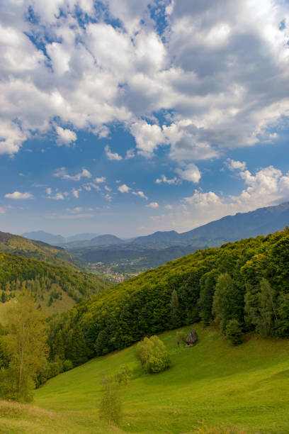 istock Rural idyllic landscape with grassy fields and rolling hills, sunny afternoon, dramatic sun rays piercing the fluffy clouds. Wonderful springtime landscape in mountains. Nature freshness concept 1470519228