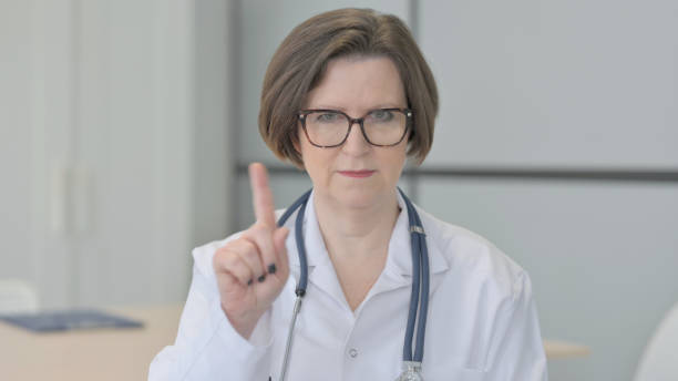 istock Restricting Senior Doctor with Denying Gesture 1470522319