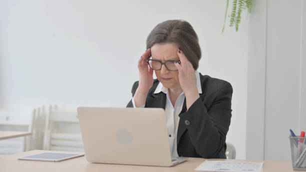 istock Old Businesswoman having Headache while Working on Laptop 1470522766