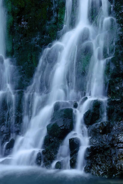 istock Beautiful mountain rainforest waterfall with fast flowing water and rocks, long exposure. Natural seasonal travel outdoor background with sun shining. Stream waterfall on rocks in the forest 1470523525