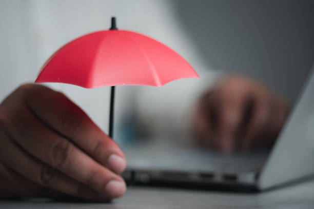 istock Man holding red toy umbrella with use computer 1470526640