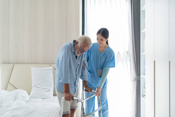 istock Young nurse helping old elderly disable man grandfather to walk using walker equipment in the bedroom 1470527090