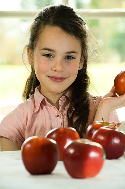 istock brown haired child presenting an apple 147052785