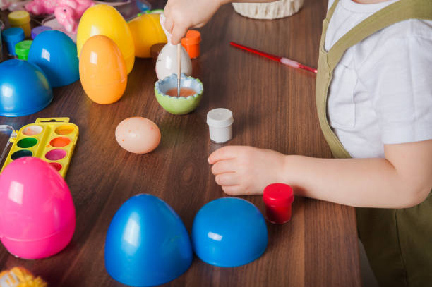 menino pintando ovo de páscoa em close-up. tradições da páscoa e entretenimento com crianças em casa - face paint child paint rabbit - fotografias e filmes do acervo