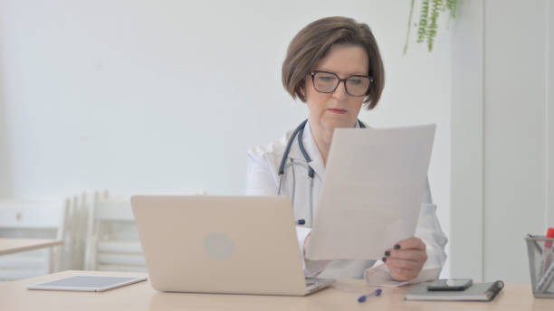 istock Senior Doctor Working on Documents and Laptop in Clinic 1470528751