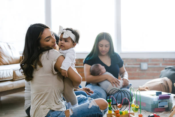 istock Sitting on floor, young moms interact with their babies 1470530517