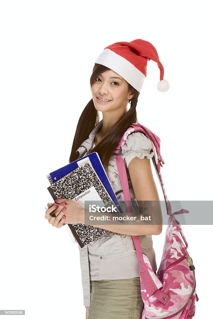 Asian student girl in Christmas Santa hat with composition book Asian school girl wearing red Santa Claus hat with backpack holding Composition book, notebooks and pen Santa Hat Stock Photo