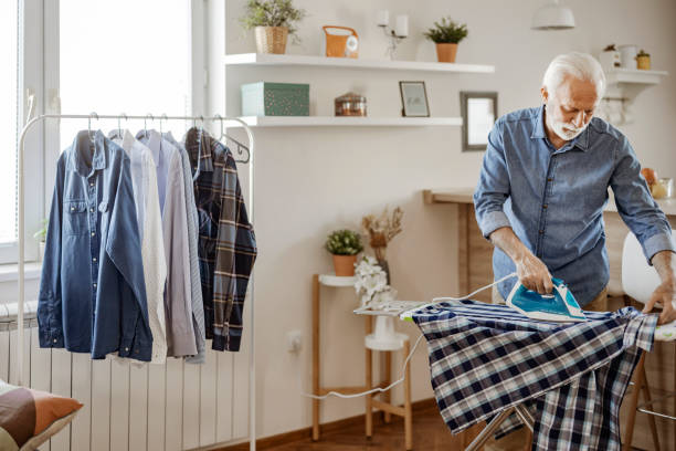 istock Elderly Man Ironing Shirt at Home 1470531533