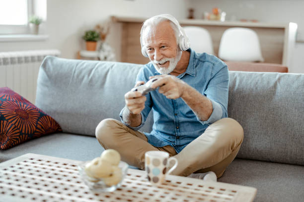 istock Elderly Man With Gamepad Playing Video Game at Home 1470531695