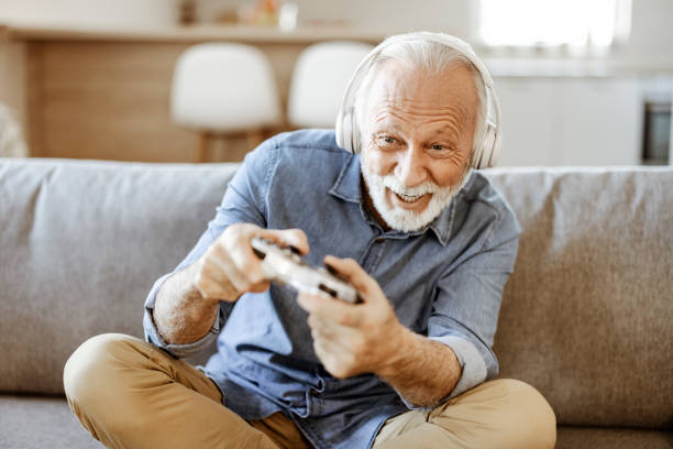 istock Elderly Man With Gamepad Playing Video Game at Home 1470532102