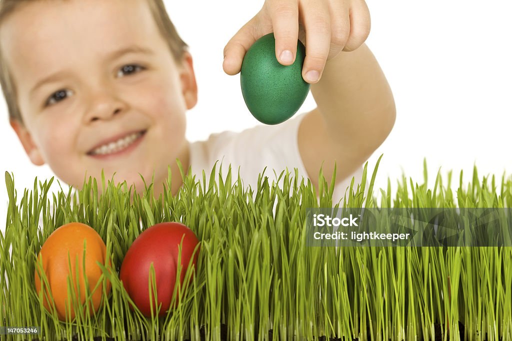 Niño feliz con huevos de Pascua en el césped - Foto de stock de Agarrar libre de derechos