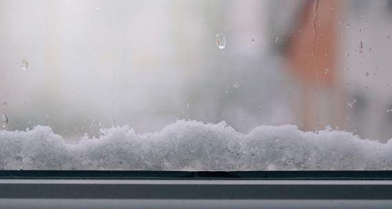 Frosted window with snow outside with sunrise background