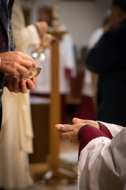 una persona en túnicas recibiendo la comunión - anglican fotografías e imágenes de stock