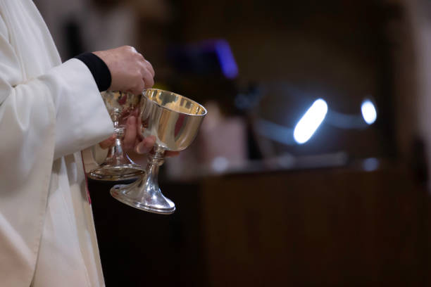 A member of the clergy holds the communion cups A member of the clergy holds the chalices used for the communion service on a sunday anglican eucharist stock pictures, royalty-free photos & images