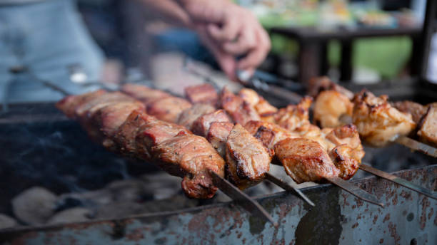 istock man grills meat kebabs on an open fire on a summer day 1470535382
