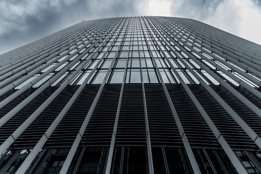 A glass facade of modern skyscraper, cloudy sky on a winter London.