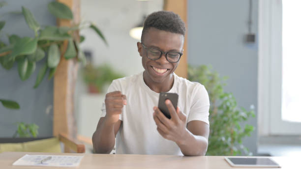 istock African Man Celebrating Success on Smartphone 1470540026