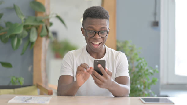 istock African Man Celebrating Win on Smartphone 1470540052